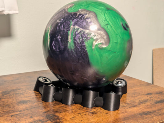 Side view of Bowling Rev Trainer showing low-profile base and steel roller bearing contact points
